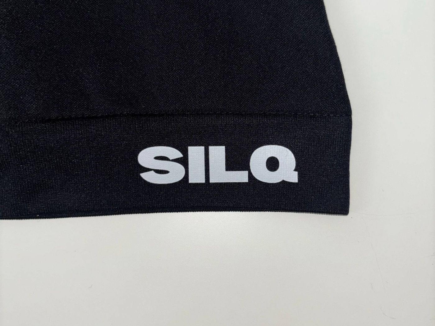 Närbild på SILQ-logotypen på skullcapens kant